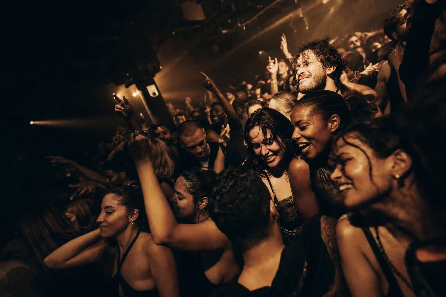 Friends moving together in a crowded late-night dance floor